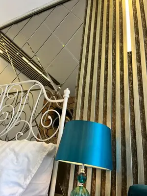a blue lamp sitting next to a bed at Апартамент Vip Vision Studio LUX in Sunny Beach