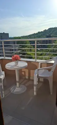 a balcony with a table and a chair and a table at Отличен Двустаен Апартамент in Primorsko