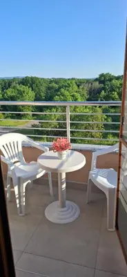 a white table and chairs on a balcony with a view at Отличен Двустаен Апартамент in Primorsko