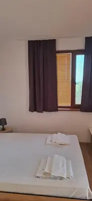 a bedroom with a bed with two towels on it at Отличен Двустаен Апартамент in Primorsko