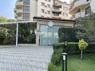 a building with a gate with a clock on it at Apartment in Long Beach in Shkorpilovtsi