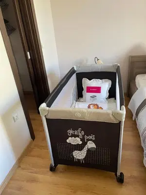 a baby crib with a box in a bedroom at Apartment in Long Beach in Shkorpilovtsi