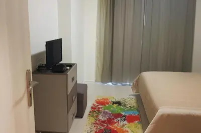 a bedroom with a bed and a tv and a rug at Star Dreams Apartment with Glass Veranda in Sveti Vlas