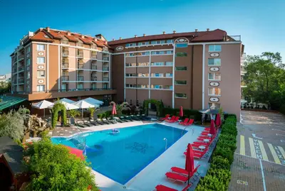 a hotel with a swimming pool and red chairs at Bratanov Bahami Residence Studio in Sunny Beach