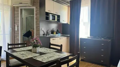 a kitchen with a dining room table with flowers on it at Bratanov Bahami Residence Studio in Sunny Beach