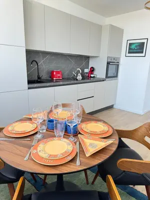a wooden table with plates and glasses on it in a kitchen at Luxus living in Burgas in Burgas City