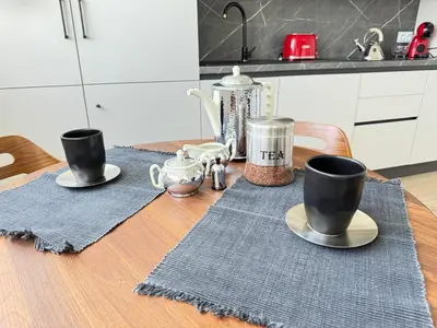 a wooden table with two cups and saucers on it at Luxus living in Burgas in Burgas City