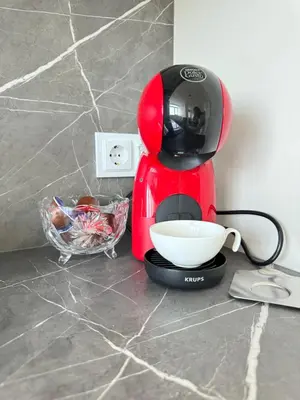 a red coffee maker sitting on a counter with a bowl at Luxus living in Burgas in Burgas City