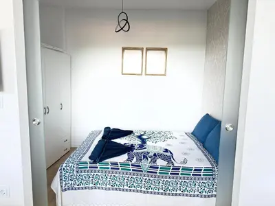 a bedroom with a bed with a blue and white quilt at Luxus living in Burgas in Burgas City