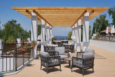 a pavilion with chairs and tables on a deck at 1 Apartment Verano Del Mar Sozopol in Sozopol