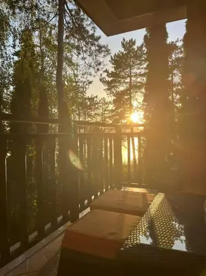 a sun shining through the trees on a deck at 1 Apartment Verano Del Mar Sozopol in Sozopol