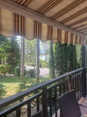 a balcony with a chair and a large window at 1 Apartment Verano Del Mar Sozopol in Sozopol