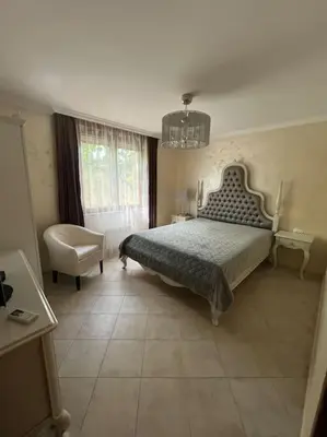 a bedroom with a bed and a chair at 2 Apartment Verano Del Mar Sozopol in Sozopol
