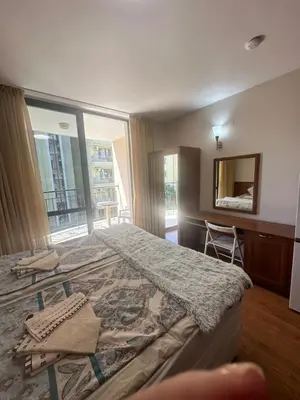 a bedroom with a large bed and a mirror at Apart Hotel Avalon in Sunny Beach