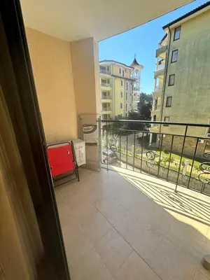a balcony with a red chair on a balcony at Apart Hotel Avalon in Sunny Beach