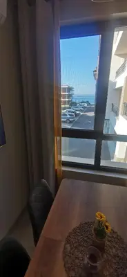 a room with a table and a window with a view at Aх, морето in Burgas City