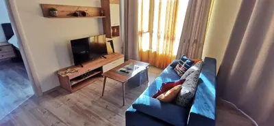 a living room with a blue couch and a tv at Aх, морето in Burgas City