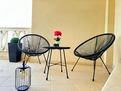 two chairs and a table with a vase with a flower at South Bay Luxury Apartment in Varna City