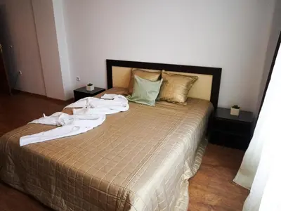 a bedroom with a bed with towels on it at Jolly apartments in Nesebar