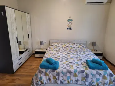 a bedroom with a bed with blue pillows on it at Studio Anelia in Sveti Vlas