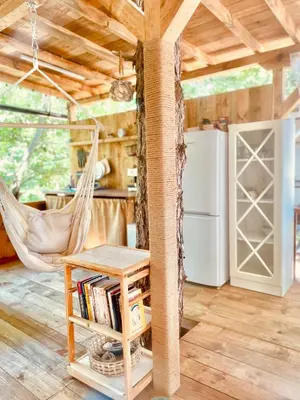 a living room with a hammock and a kitchen at Каравана Безвремие in Chernomorets