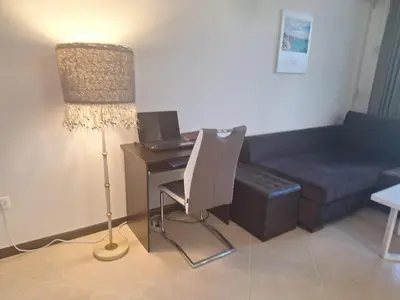a living room with a desk with a lamp and a couch at Bogdanov in Lozenets