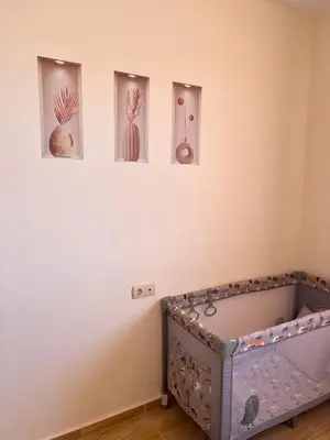 a room with four pictures on a wall with a crib at the magic dream, Sveti Vlas in Sveti Vlas