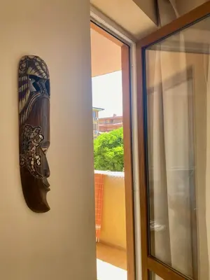 a mask hanging on a wall next to a window at the magic dream, Sveti Vlas in Sveti Vlas