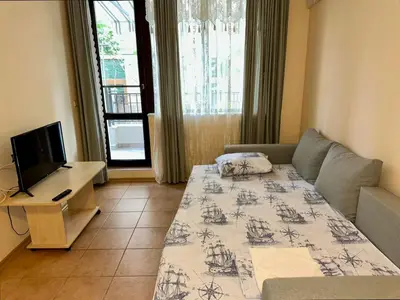 a living room with a couch and a television at Sozopol Dreams - Apartment 1 in Sozopol