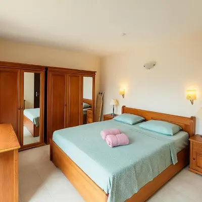 a bedroom with a bed with two pink pillows on it at Rose Village Private Apartment in Sunny Beach