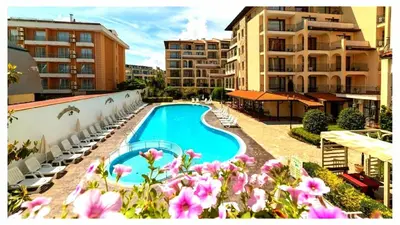 a view of a swimming pool with chairs and buildings at Rose Village Private Apartment in Sunny Beach