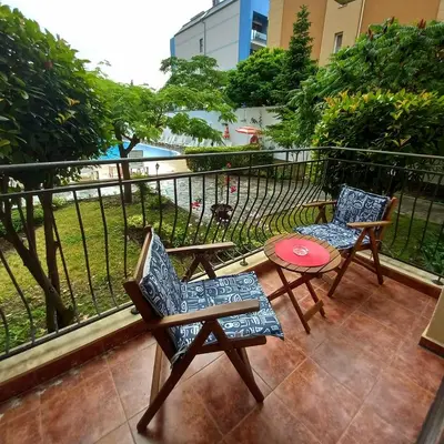 a balcony with two chairs and a table and a fence at Rose Village Private Apartment in Sunny Beach