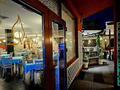 a restaurant with blue tables and chairs in front of a window at Rose Village Private Apartment in Sunny Beach