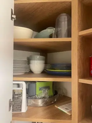 a cabinet filled with dishes and bowls and plates at Апартамент за нощувки в ЕЛИТ 4 Слънчев бряг in Sunny Beach