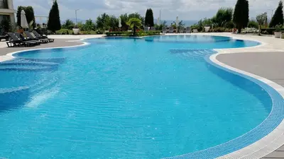 a large swimming pool with blue water at Beachfront one bedroom apartment DIAMOND BEACH Burgas Sarafovo Студио в Diamond beach Сарафово in Burgas City
