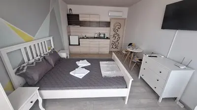 a small bedroom with a bed and a kitchen at Beachfront one bedroom apartment DIAMOND BEACH Burgas Sarafovo Студио в Diamond beach Сарафово in Burgas City