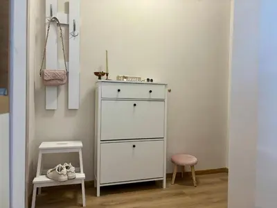 a white dresser in a room with a stool at Triumph apartment in Burgas City