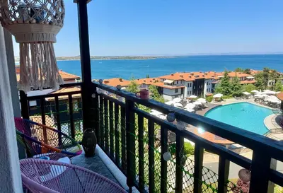 a balcony with a view of a swimming pool and the ocean at Apartment Anastasia Santa Marina in Sozopol