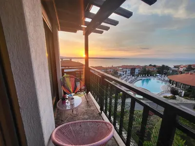 a balcony with a table and chairs and a pool at Apartment Anastasia Santa Marina in Sozopol