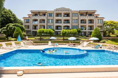 a swimming pool in front of a large building at Apartment in Paradise View complex in Sozopol