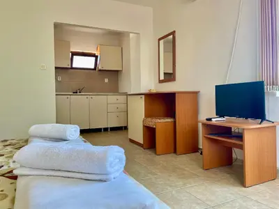 a room with a desk with two towels on a bed at Къща за Гости Чайка in Byala