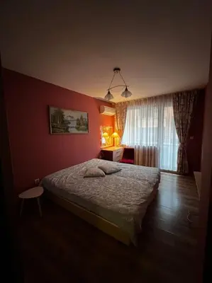 a bedroom with a bed and a red wall at GREAT Apartament in Burgas City