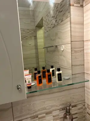 a bathroom with a glass shelf withentedentedentedented candles at GREAT Apartament in Burgas City