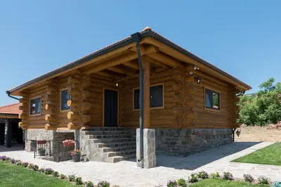 a log cabin with a staircase in front of it at Къщи за гости Стара Голица in Golitsa