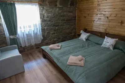 a bedroom with a green bed and a window at Къщи за гости Стара Голица in Golitsa