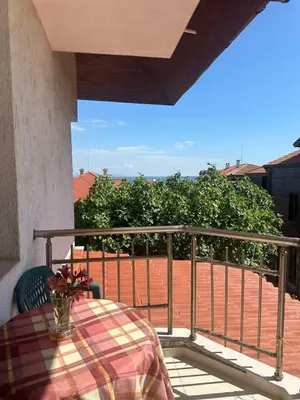 a table with a vase on a balcony with a view at апартамент под наем виа понтика in Sozopol