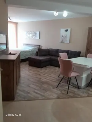 a living room with a couch and a table and chairs at студио Орхидея Сарафово лукс с изглед към морето in Burgas City