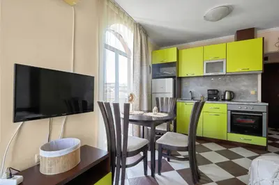 a kitchen with yellow cabinets and a table with chairs at Hacienda Beach Studio with Pool by Flat Mаnаger in Sozopol