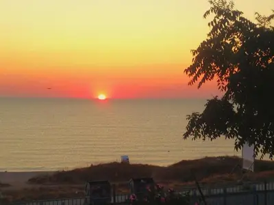 a sunset over the ocean with the sun setting at Apartment Divna in Sozopol
