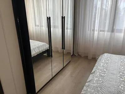a dresser with a mirror next to a bed at На гости в Созопол in Sozopol